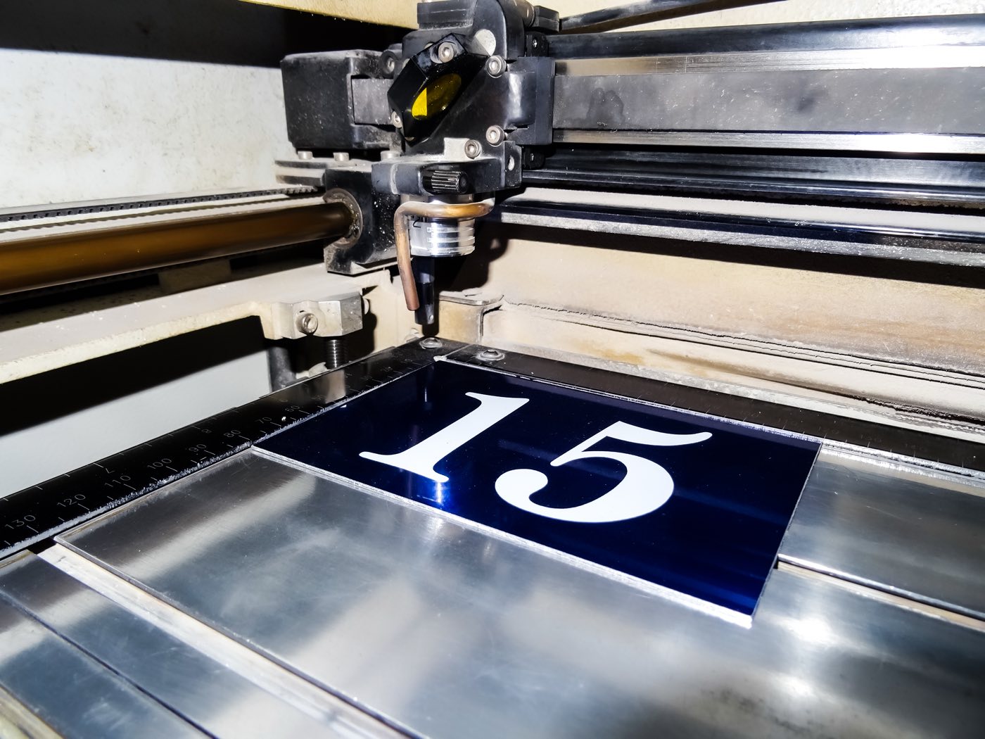 Une plaque bleue gravée du numéro 15 sur la machine à graver