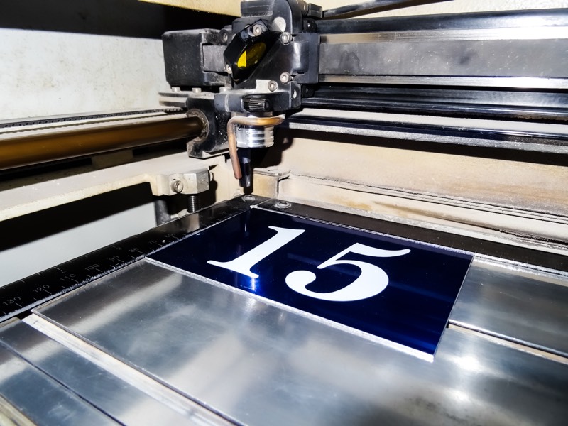 Une plaque bleue gravée du numéro 15 sur la machine de gravure laser